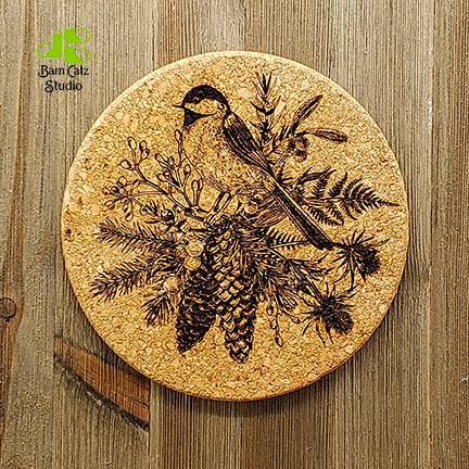 Vintage hand-drawn style bird in pine and holly branches lends a sophisticated touch to a traditional Christmas meal.  Natural cork trivet is laser engraved to match the Christmas Cork Coaster Set. Trivet is 7” in diameter, and ½” thick.